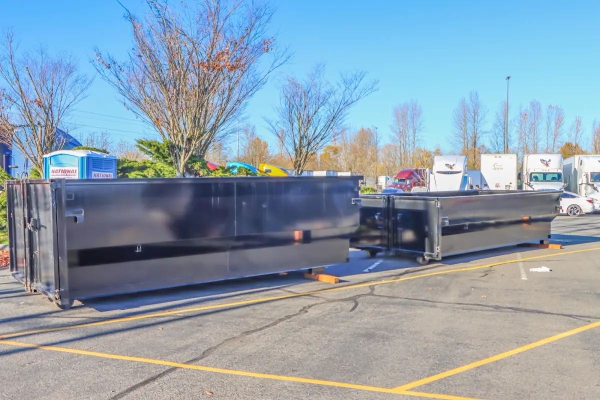 Professional dumpster rental service with roll-off container on residential driveway in Cumberland